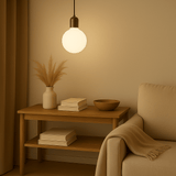 Nestled corner with a wooden side table, books, a vase with plants, and a bowl, illuminated by a pendant light.